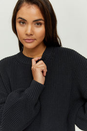 Frau in schwarzem Strickpullover blickt kamera