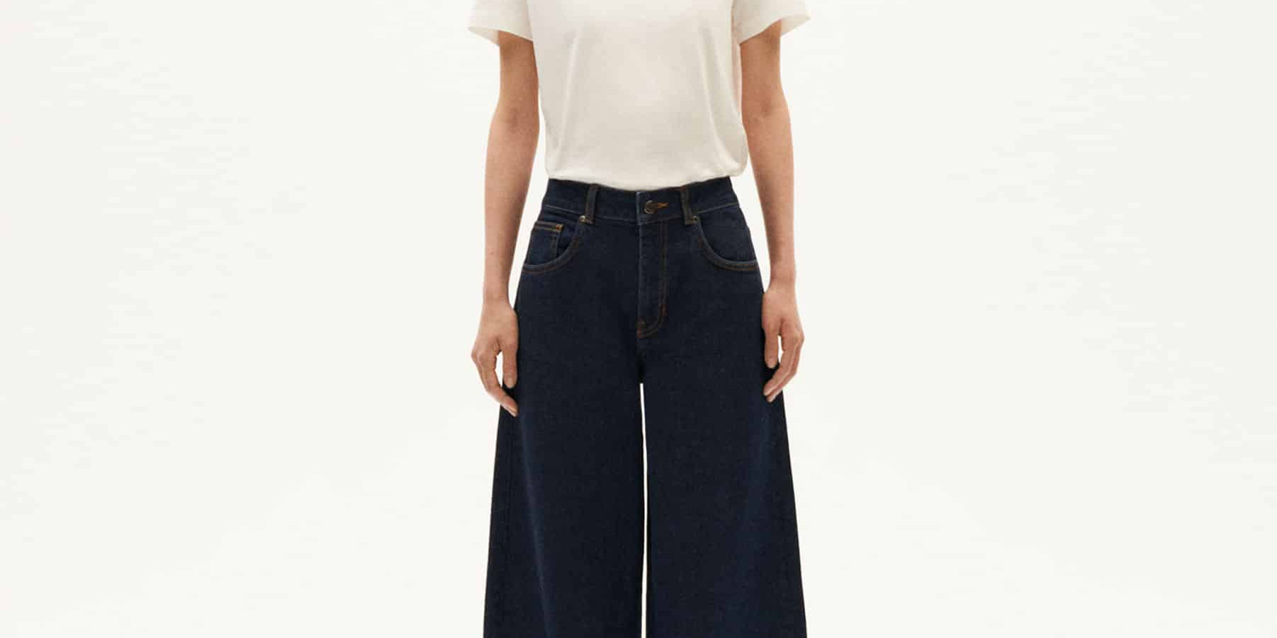Frau in weißen Shirt und weiten Jeans