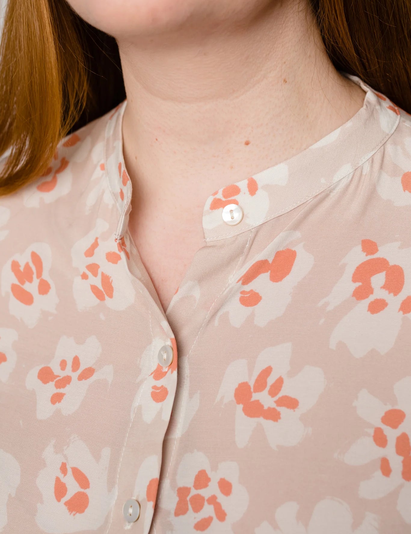 Frau in Bluse mit Blumenmuster, Nahaufnahme.