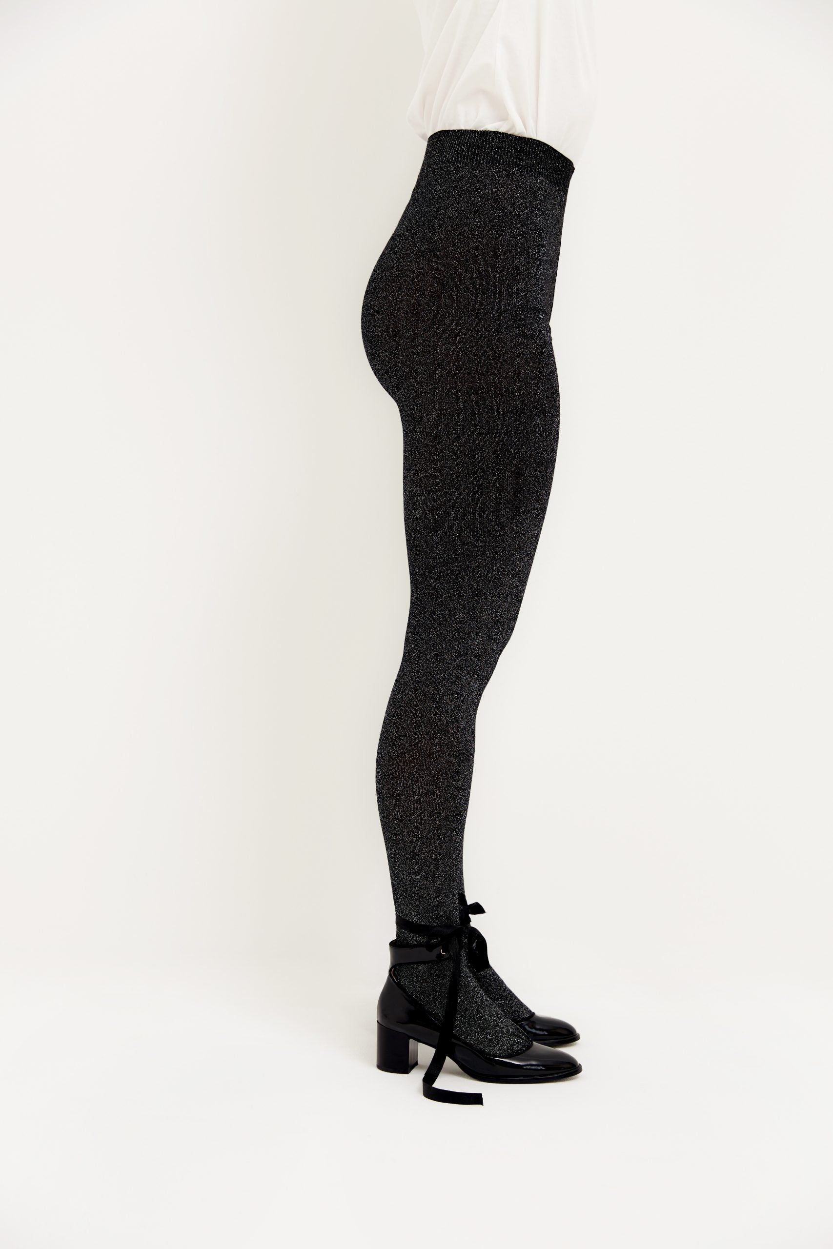 Frau in glitzernder schwarzer Hose und Schuhen