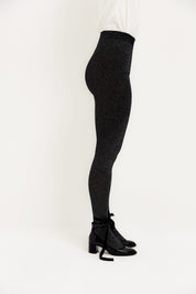 Frau in glitzernder schwarzer Hose und Schuhen