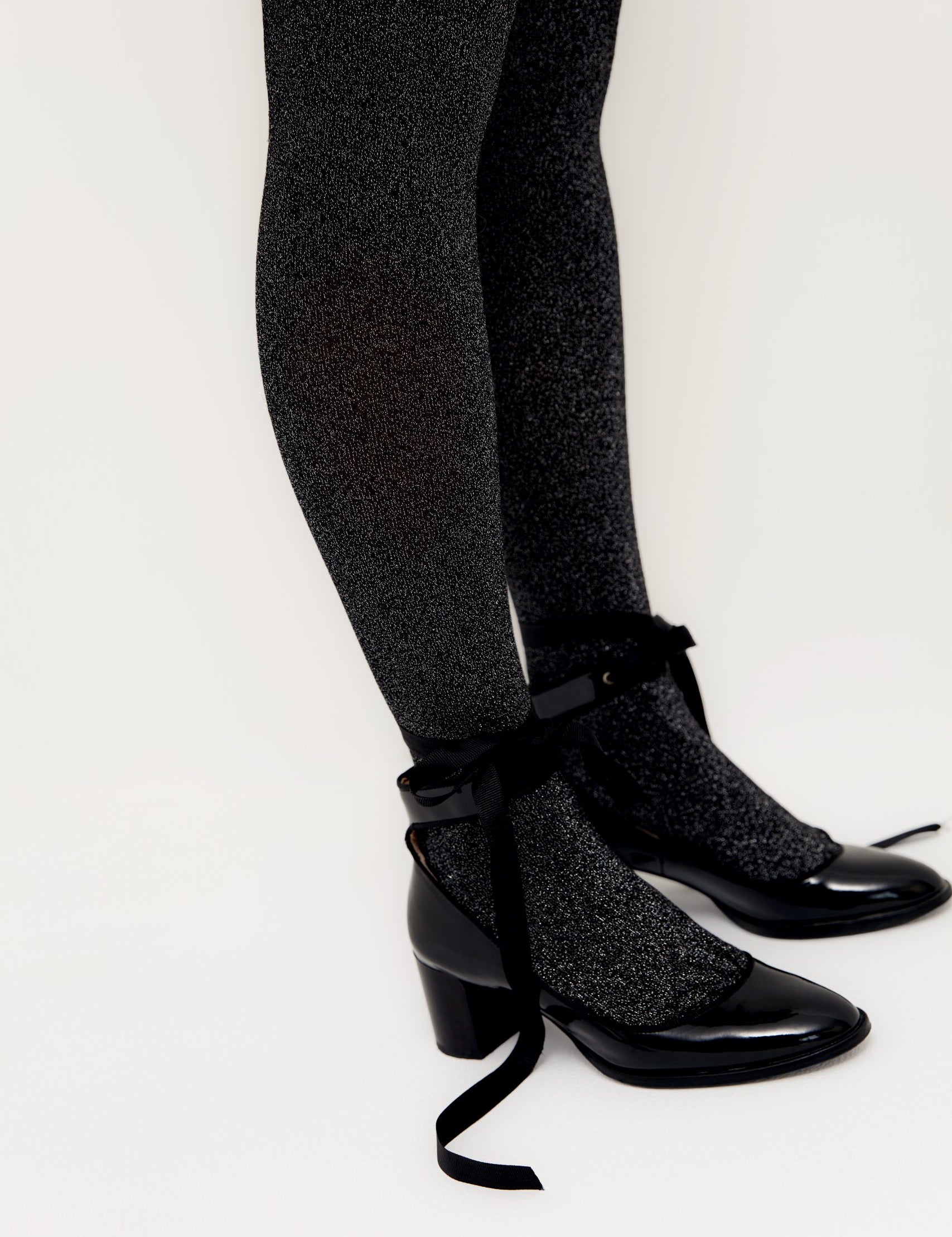 Glitzernde Strumpfhosen und schwarze Schnürschuhe