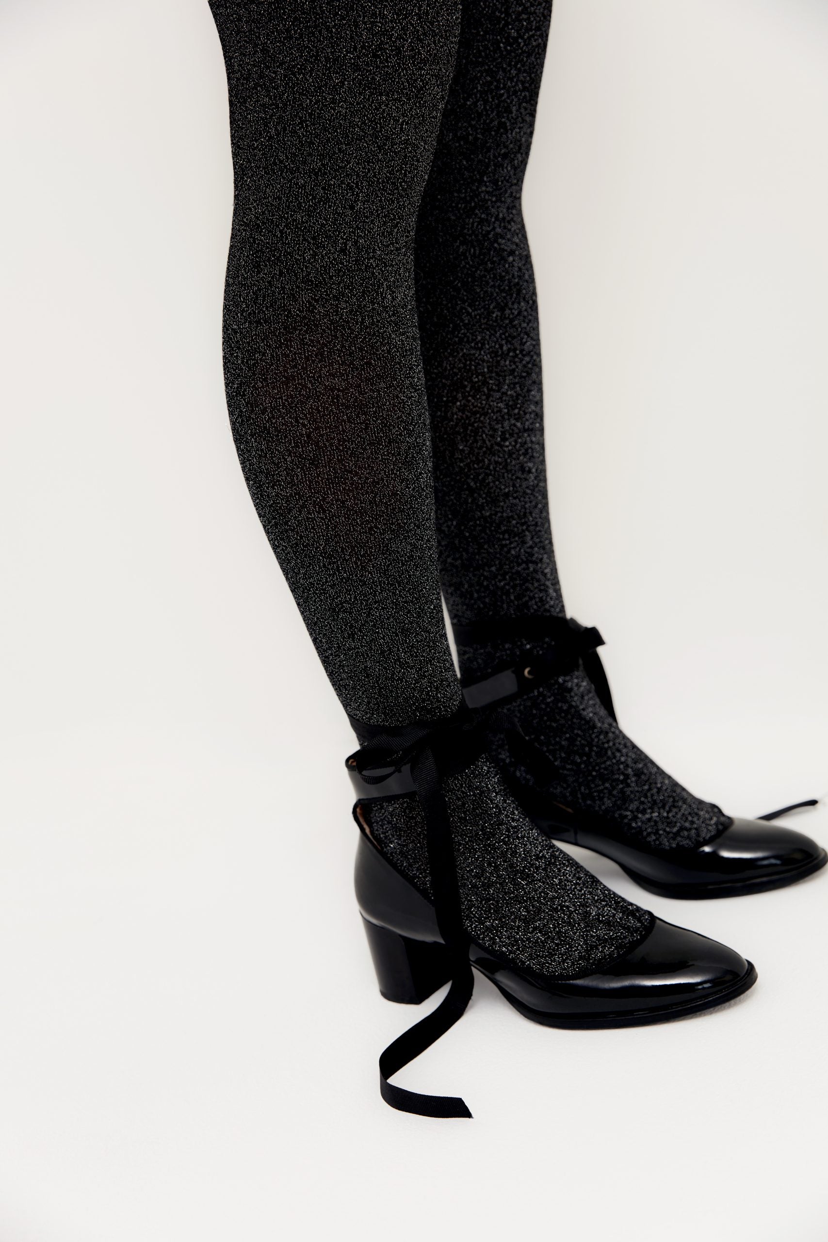 Glitzernde Strumpfhosen und schwarze Schnürschuhe