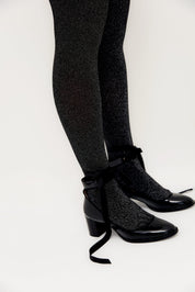 Glitzernde Strumpfhosen und schwarze Schnürschuhe