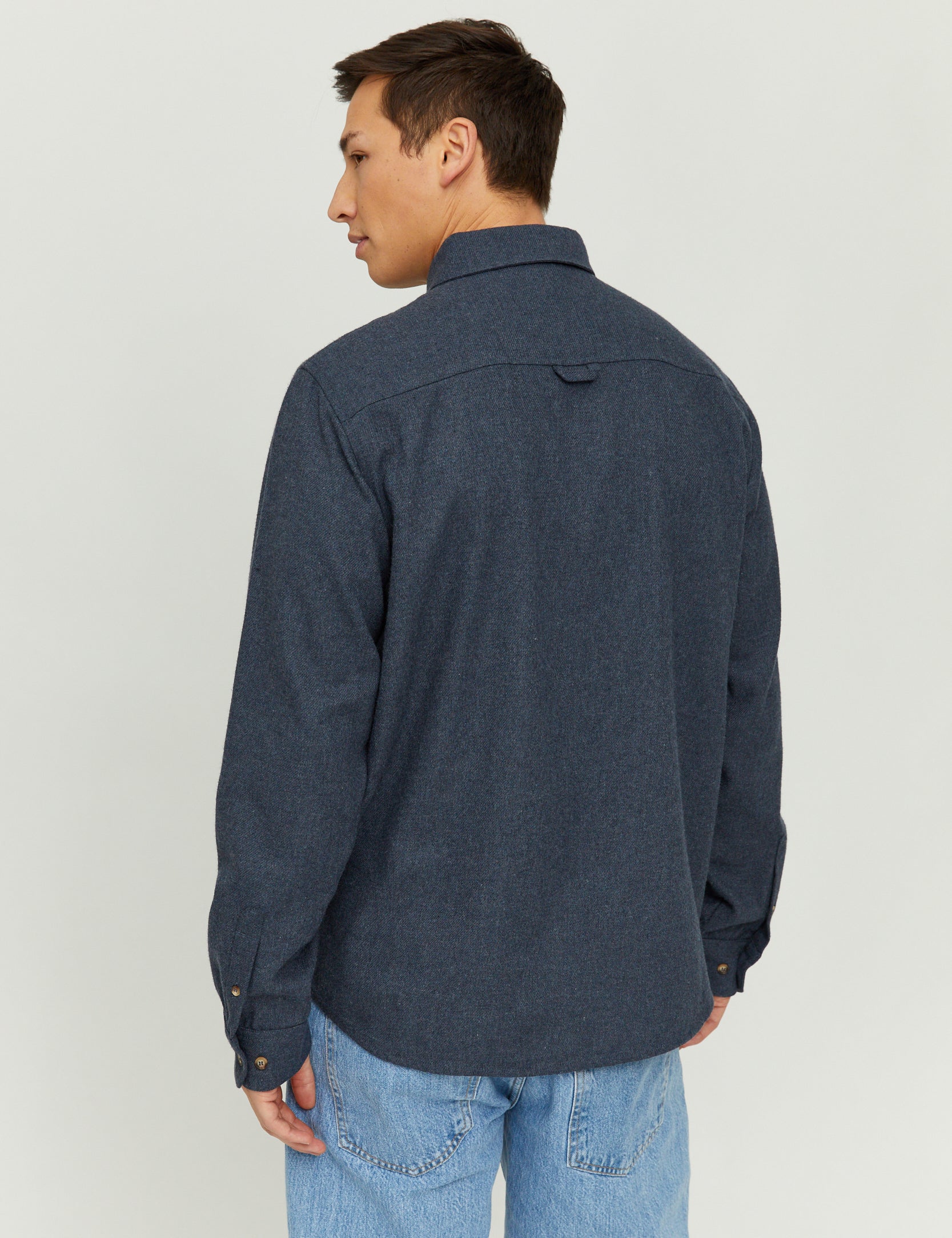 Mann trägt blaues Jeanshemd, Rückansicht