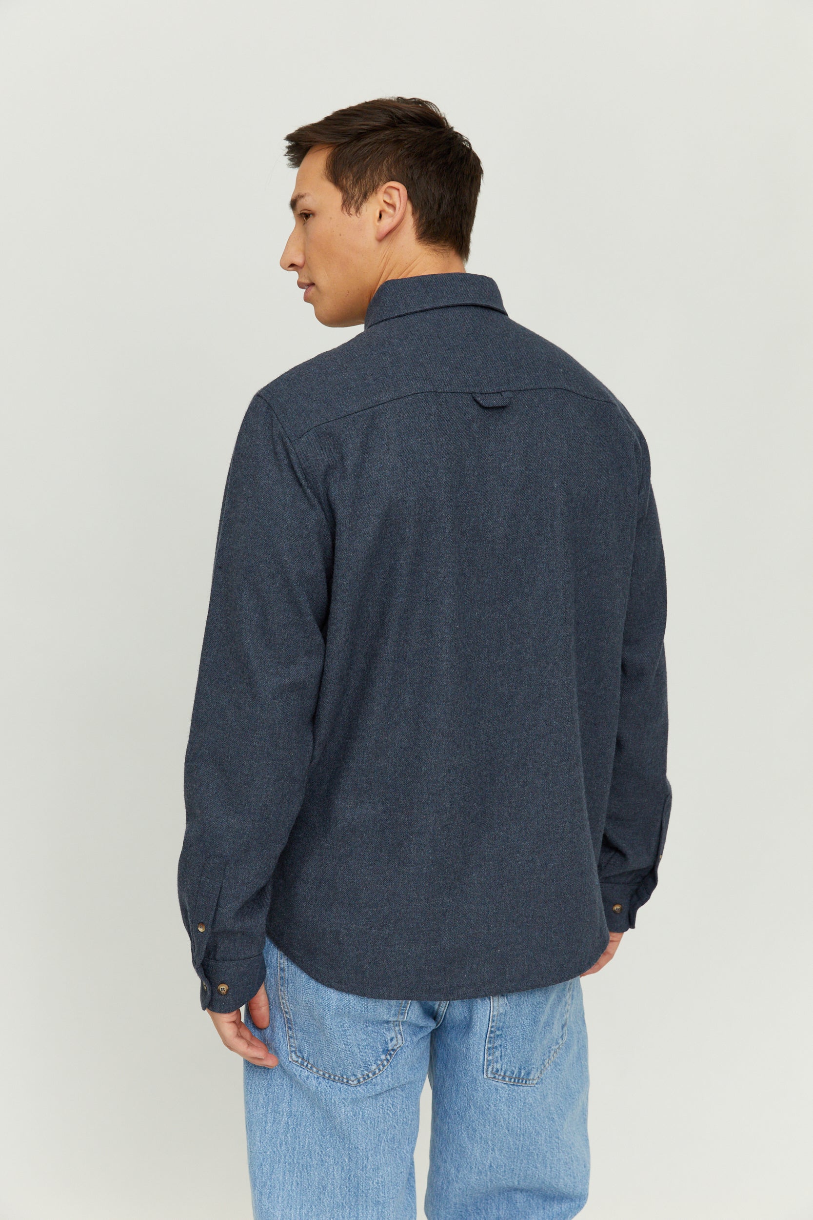 Mann trägt blaues Jeanshemd, Rückansicht