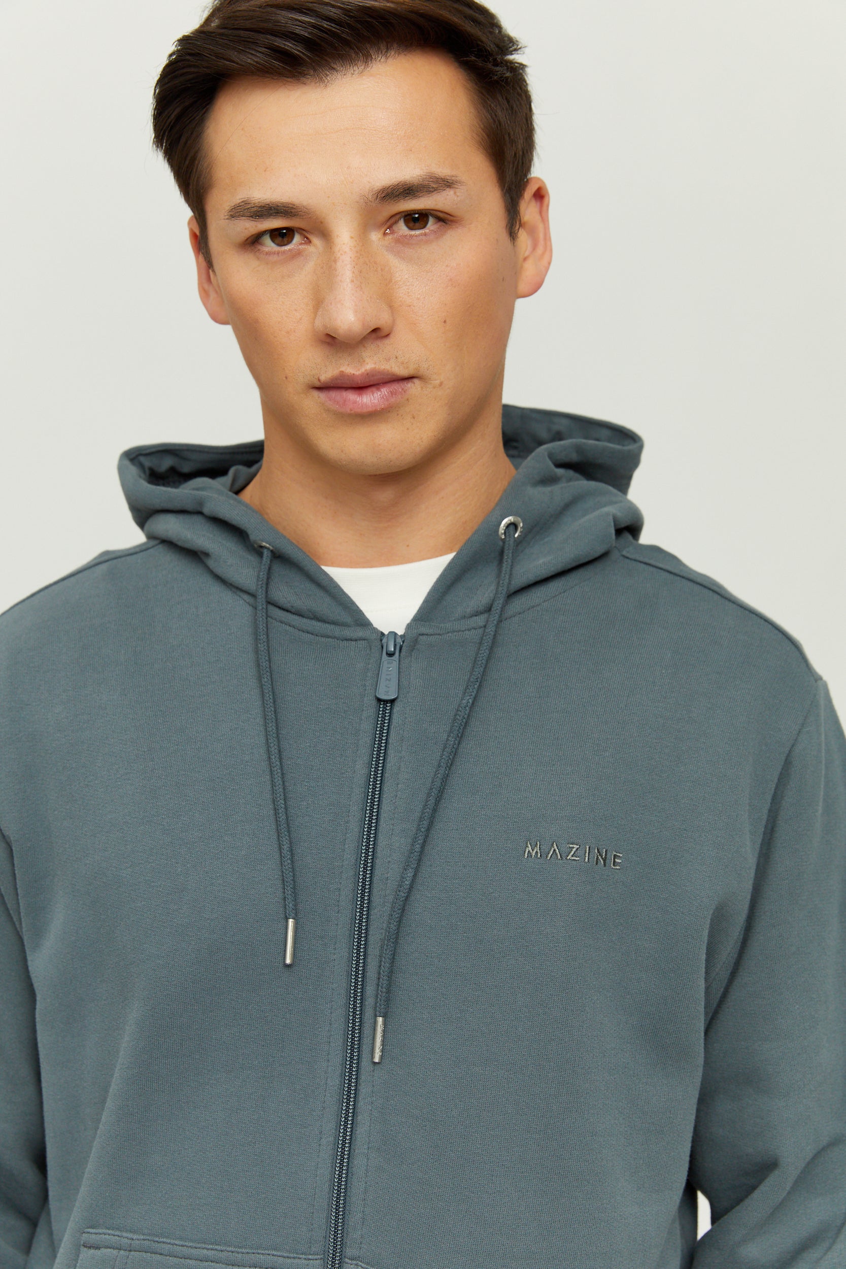 Mann in grauem Kapuzenpullover, ernster Blick