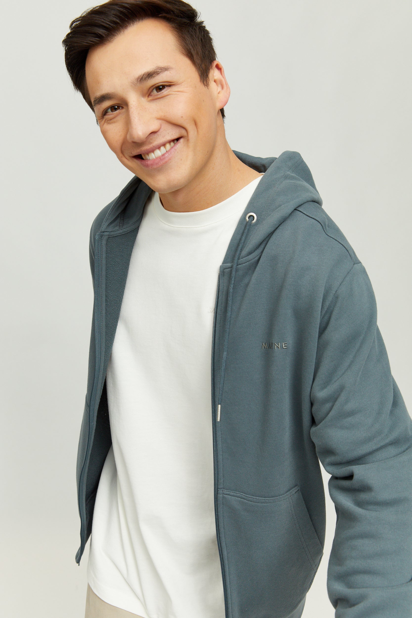 Lächelnder Mann in weißem Shirt und blauer Jacke