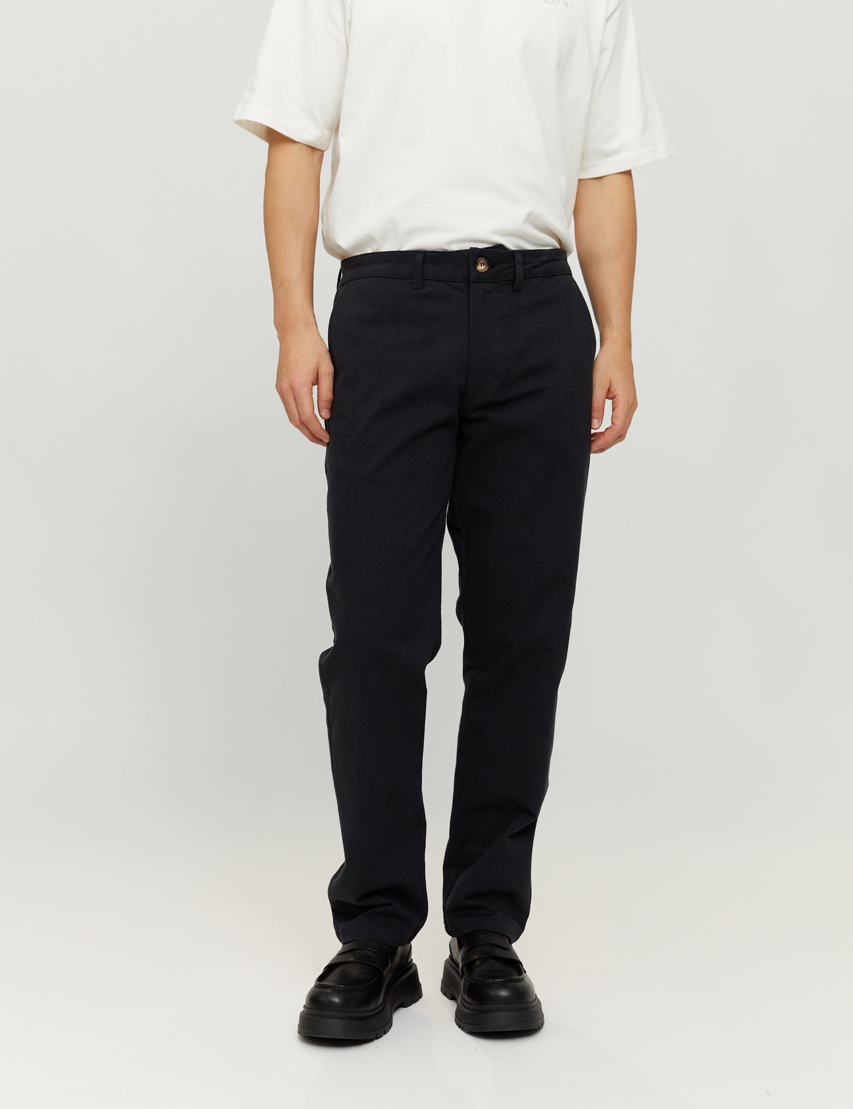 Person trägt weiße Bluse und schwarze Hose