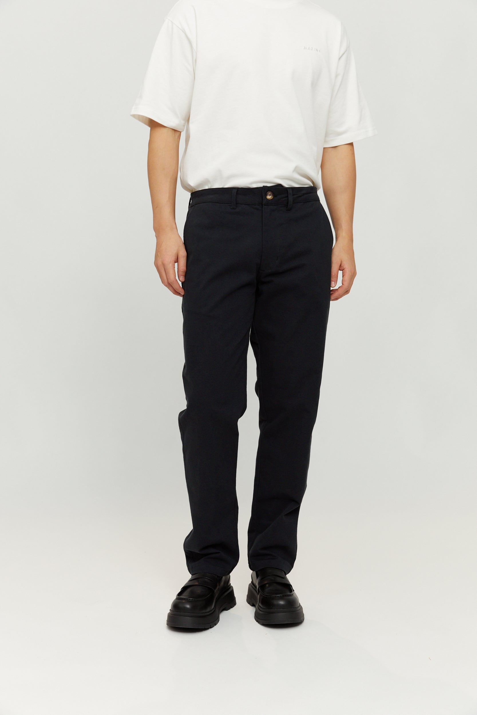 Person trägt weiße Bluse und schwarze Hose