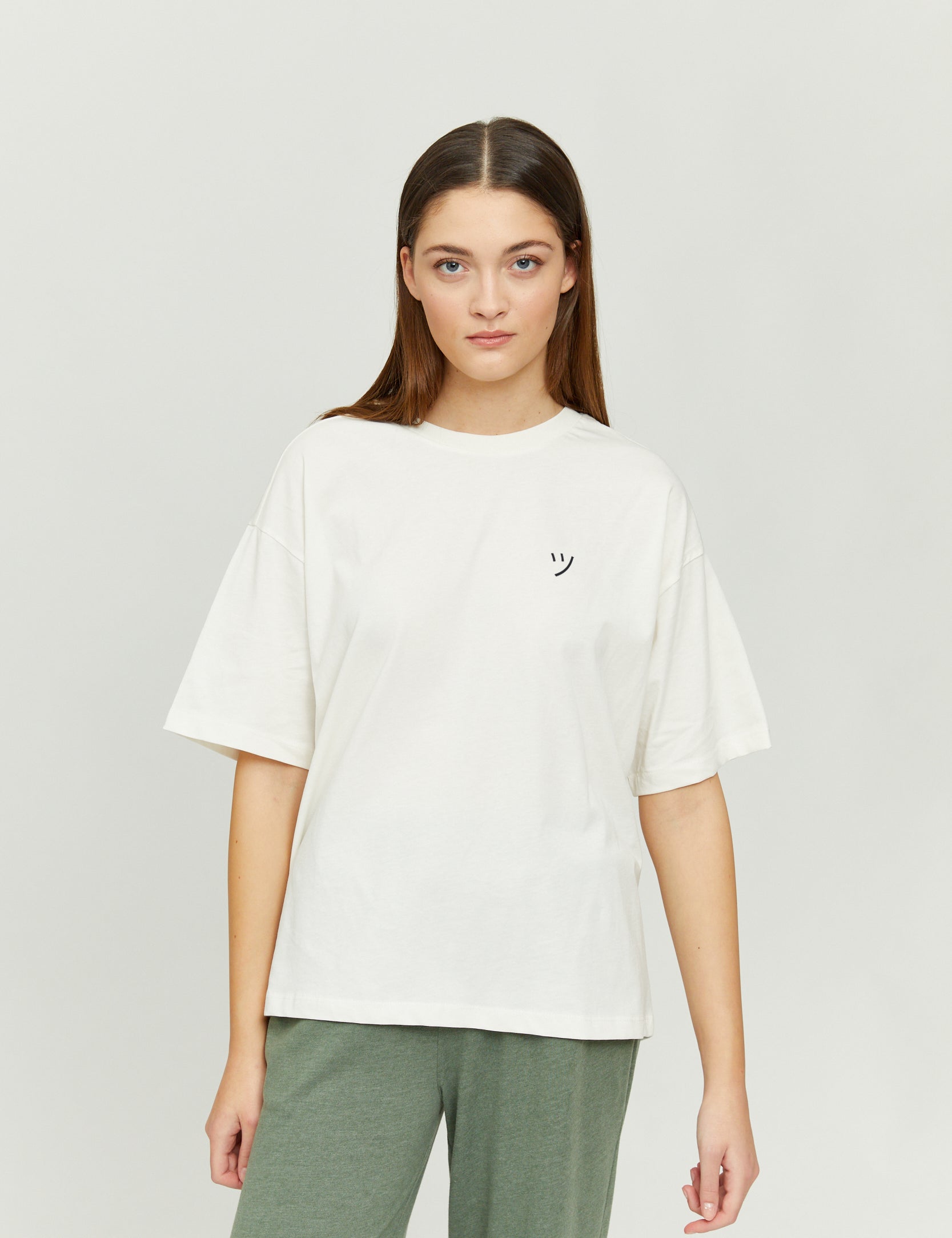 Frau in weißem T-Shirt mit Smiley-Logo