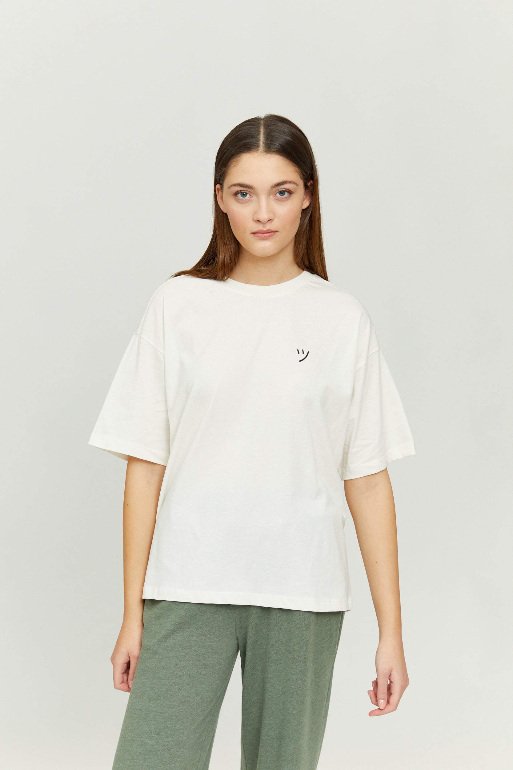 Frau in weißem T-Shirt mit Smiley-Logo
