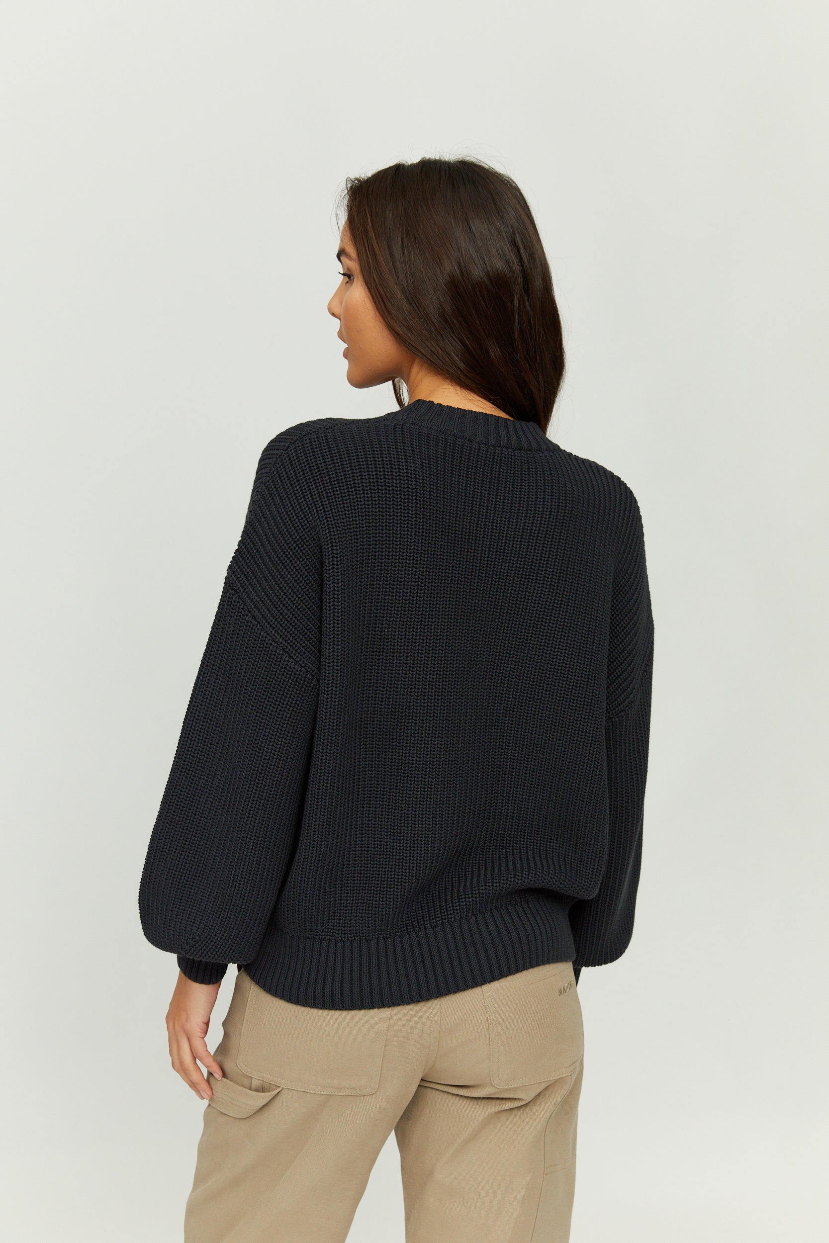 Frau trägt schwarzen Pullover, von hinten