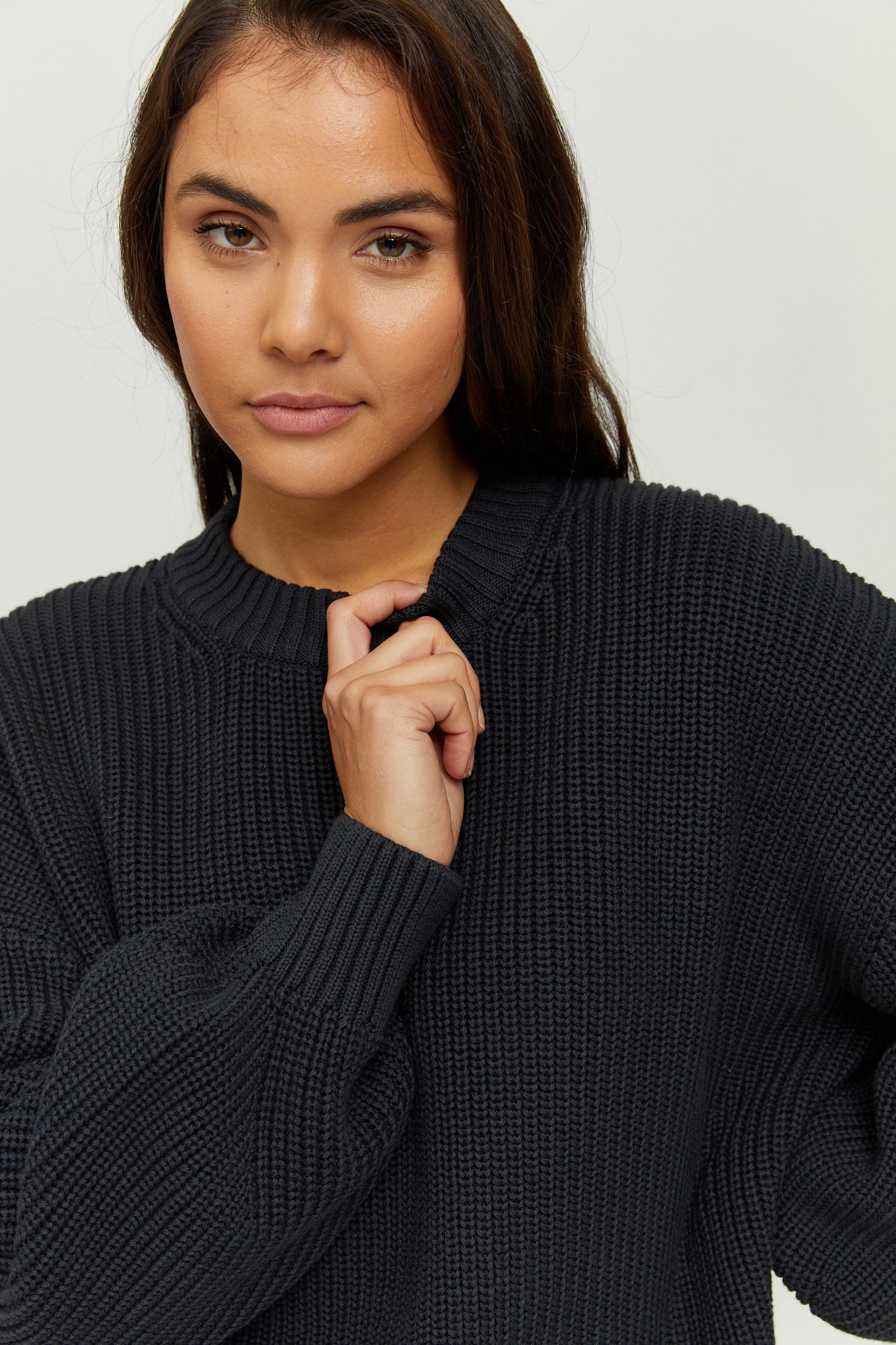 Frau in schwarzem Strickpullover blickt kamera