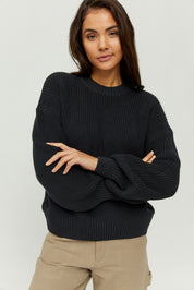 Frau in schwarzem Pullover posiert