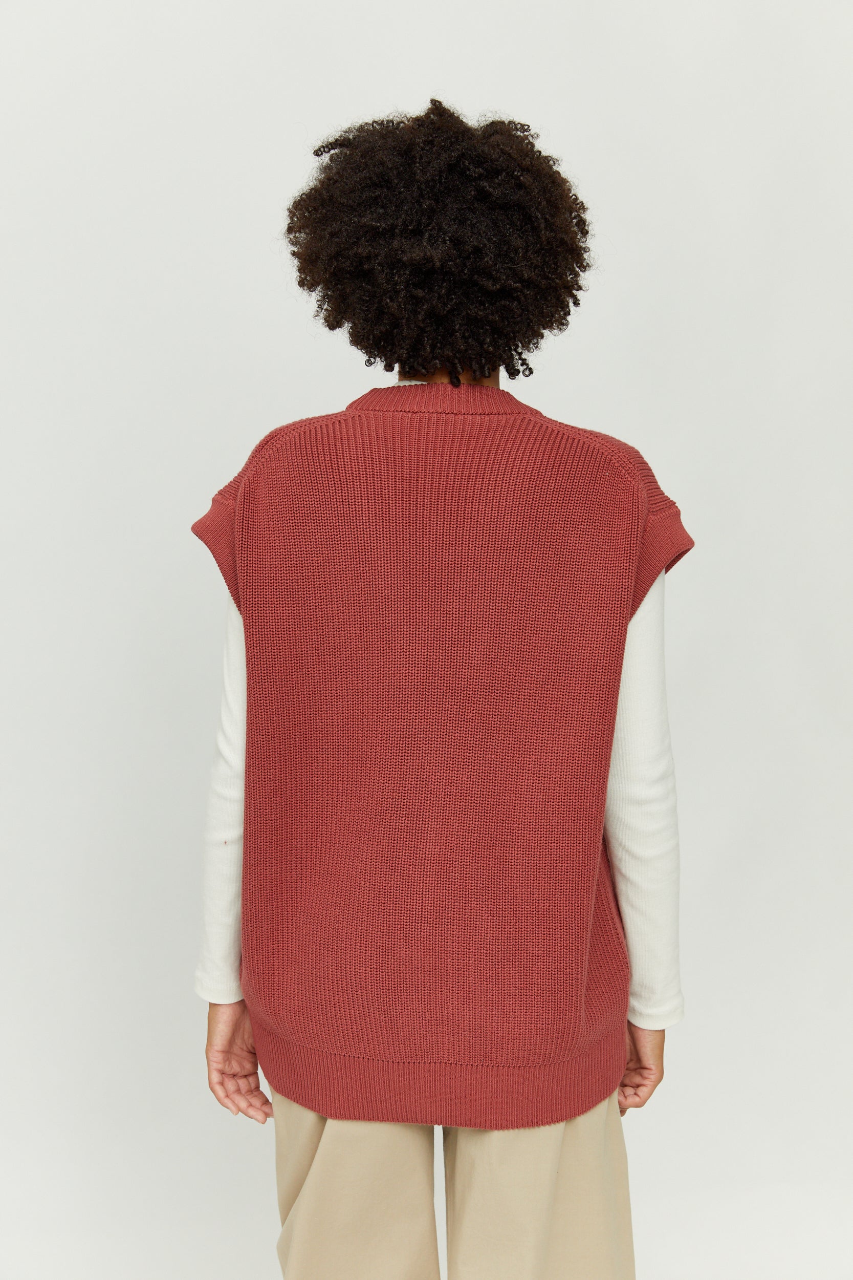 Person trägt roten Strickpullover, Rückansicht