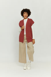 Frau in beiger Hose und rotem Strickweste