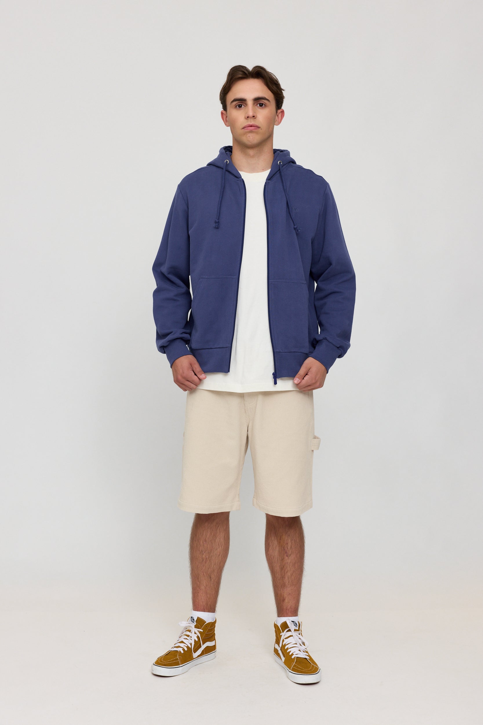 Mann in blauer Jacke und beigen Shorts