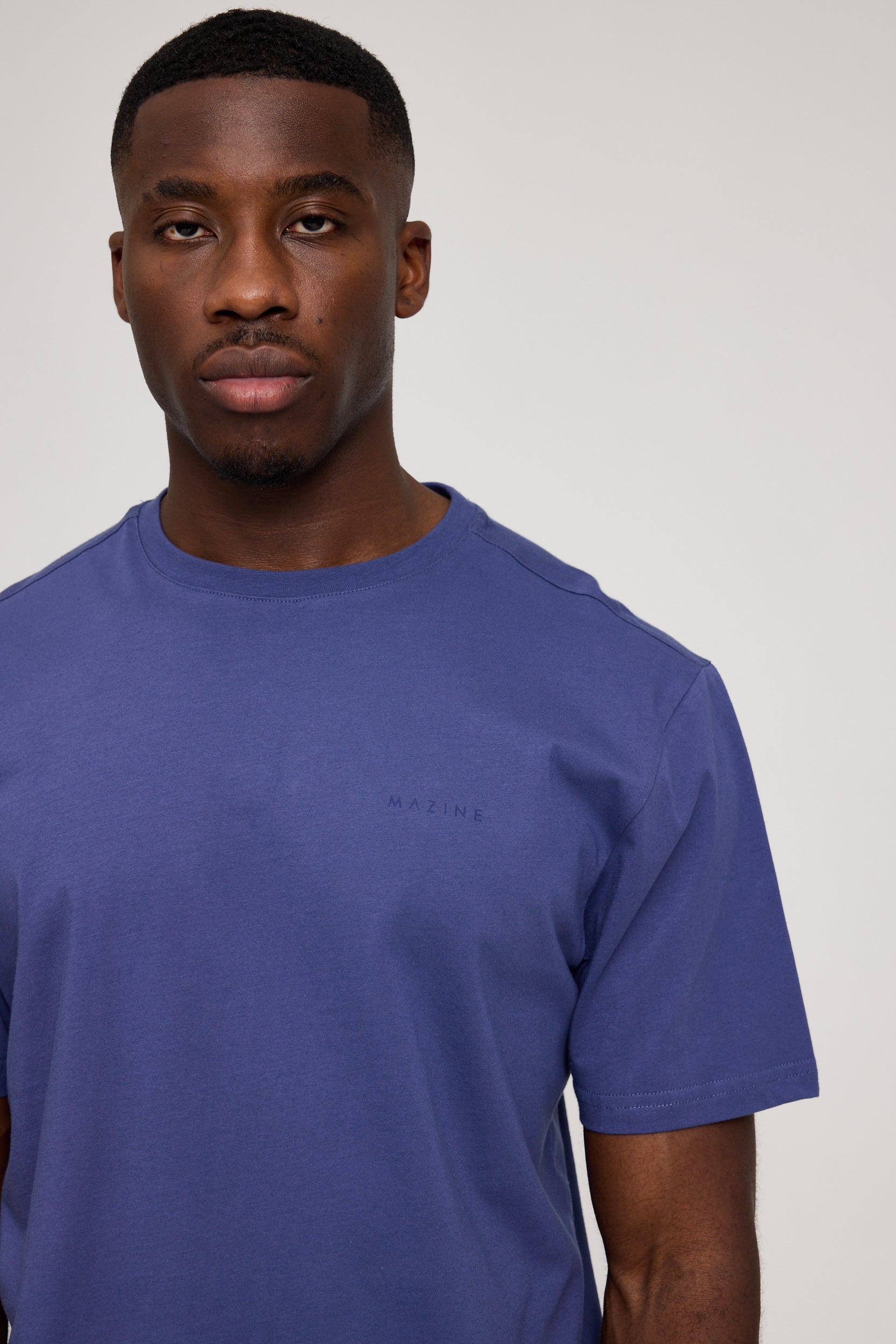 Mann in blauem T-Shirt schaut ernst