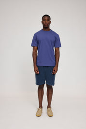 Mann in blauem Shirt und kurzen Jeans
