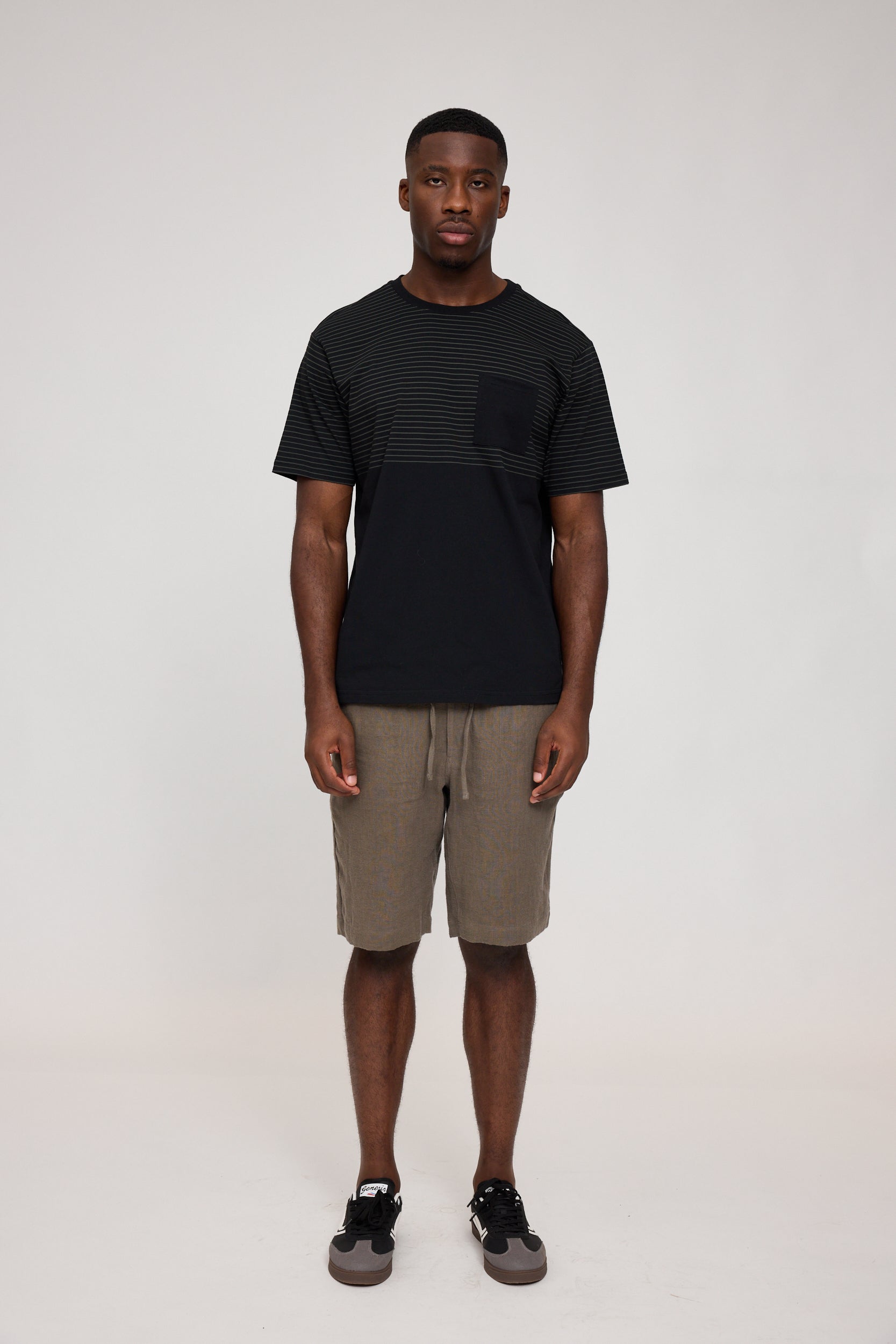 Mann in T-Shirt und Shorts vor weißem Hintergrund