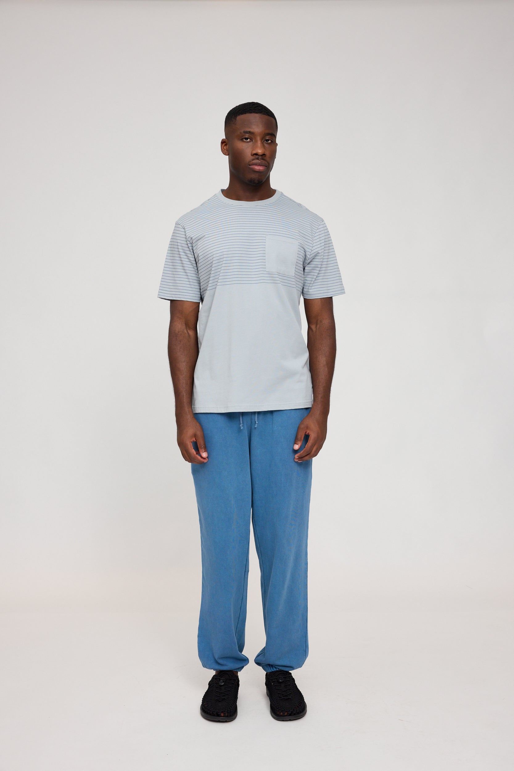 Mann in gestreiftem Shirt und blauen Hosen