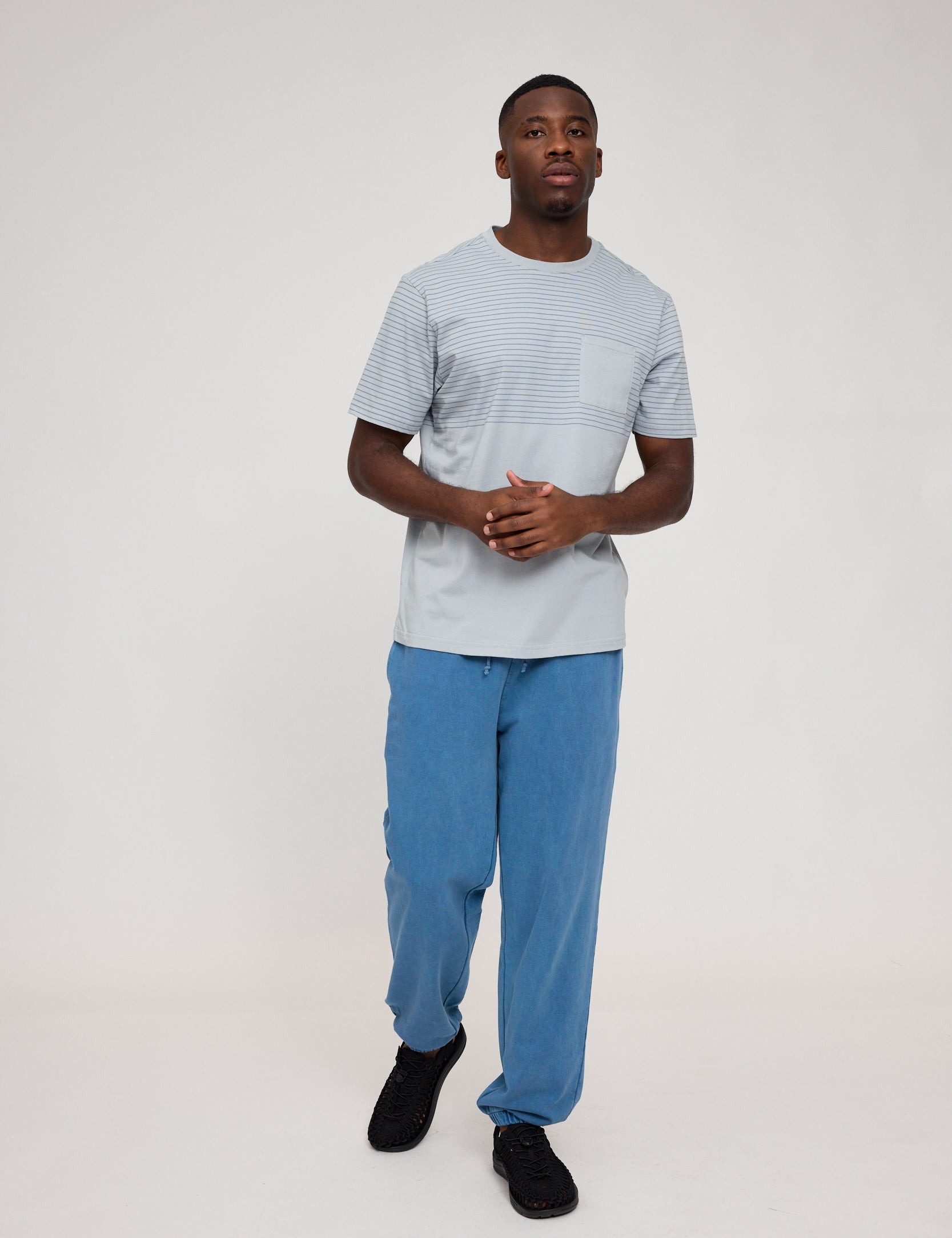 Mann in blauem Outfit auf weißem Hintergrund