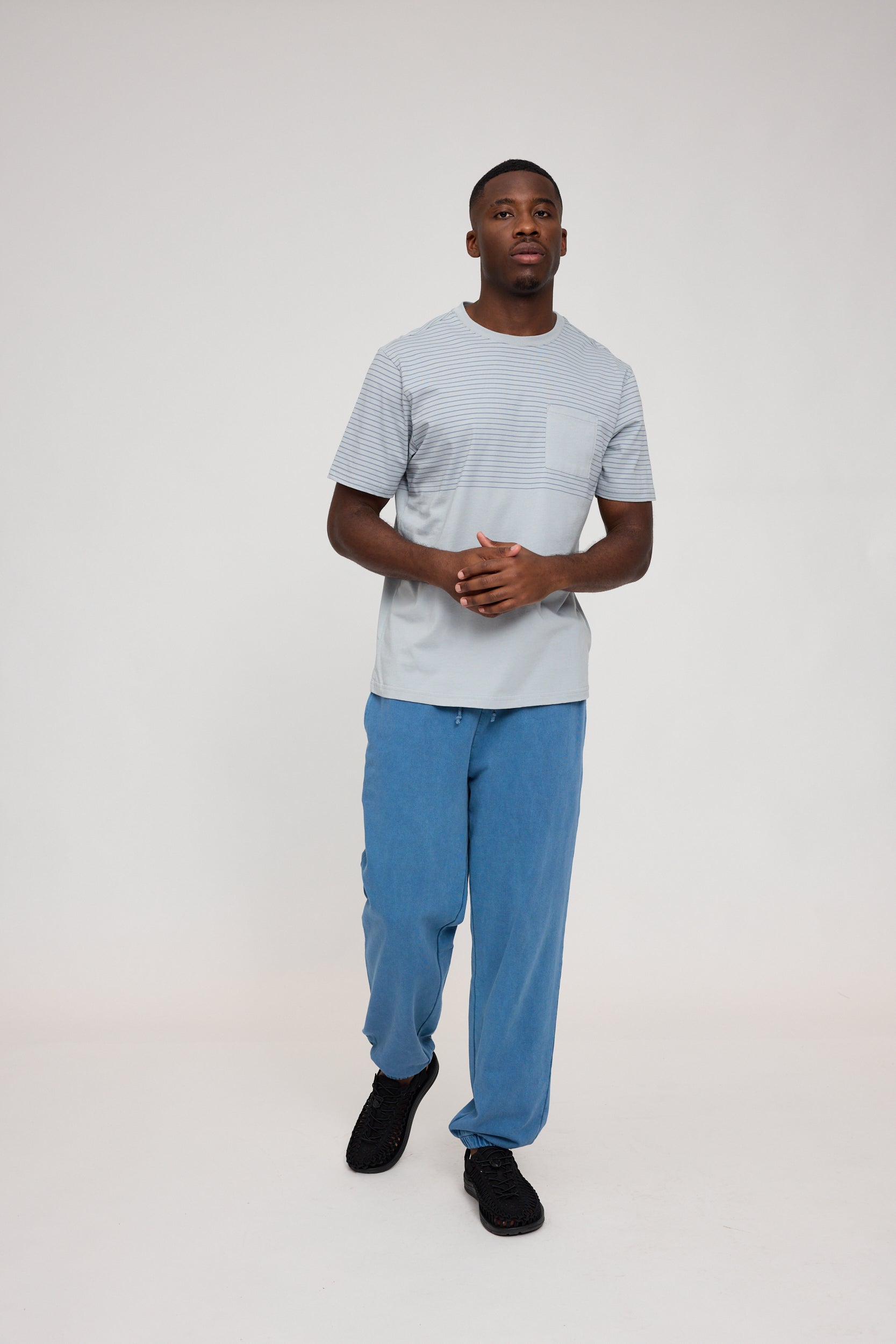 Mann in blauem Outfit auf weißem Hintergrund