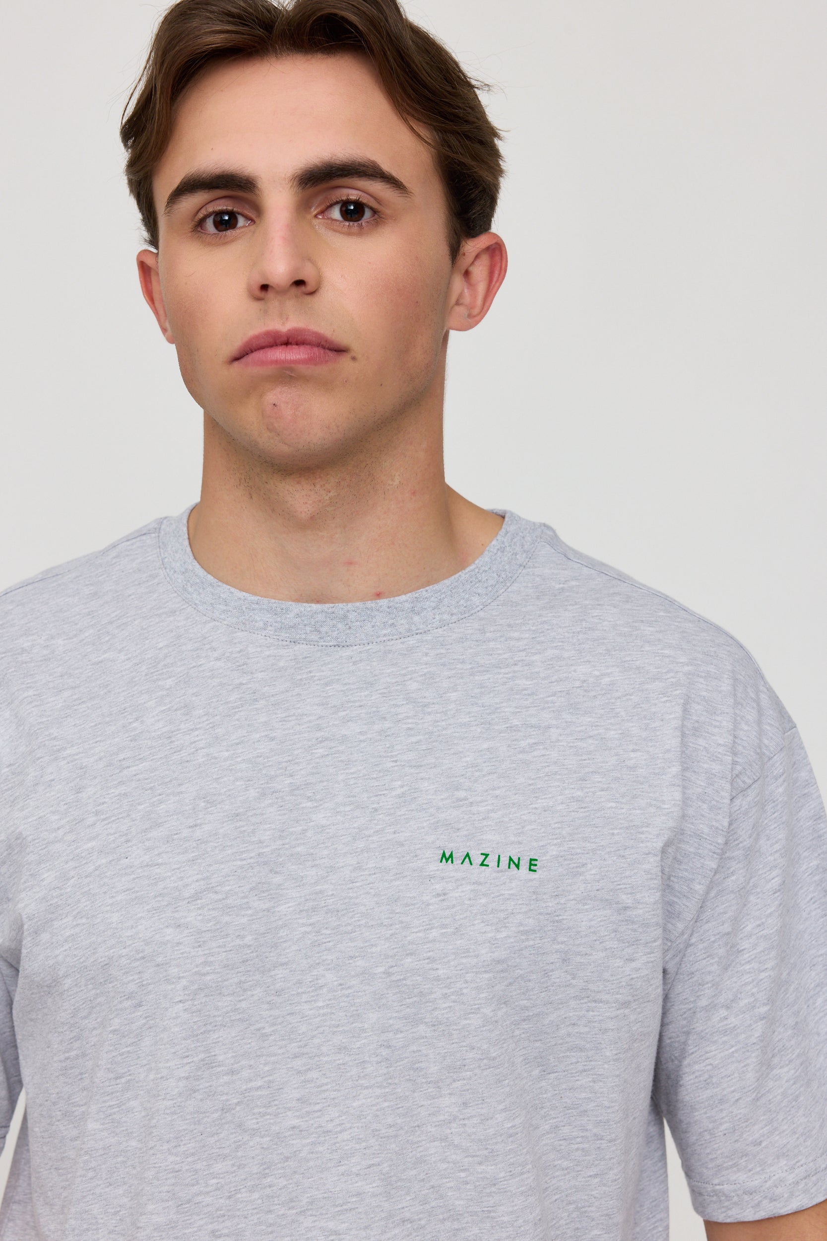 Junger Mann in grauem T-Shirt mit Logo