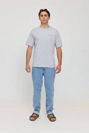 Junger Mann in grauem T-Shirt und Jeans