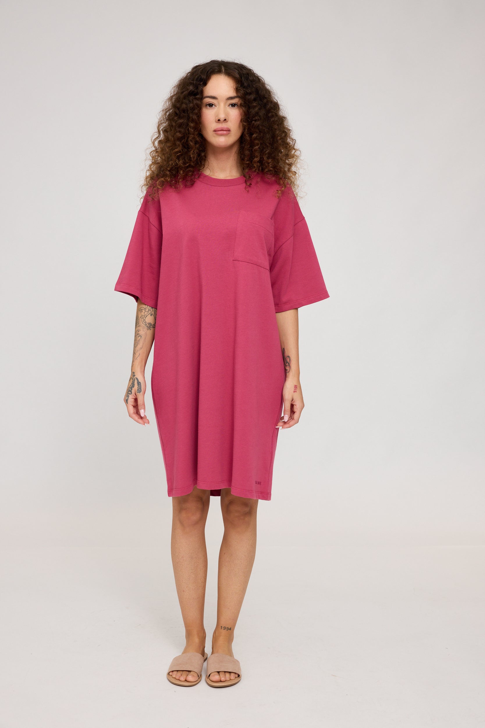 Frau in rosa Kleid posiert im Studio