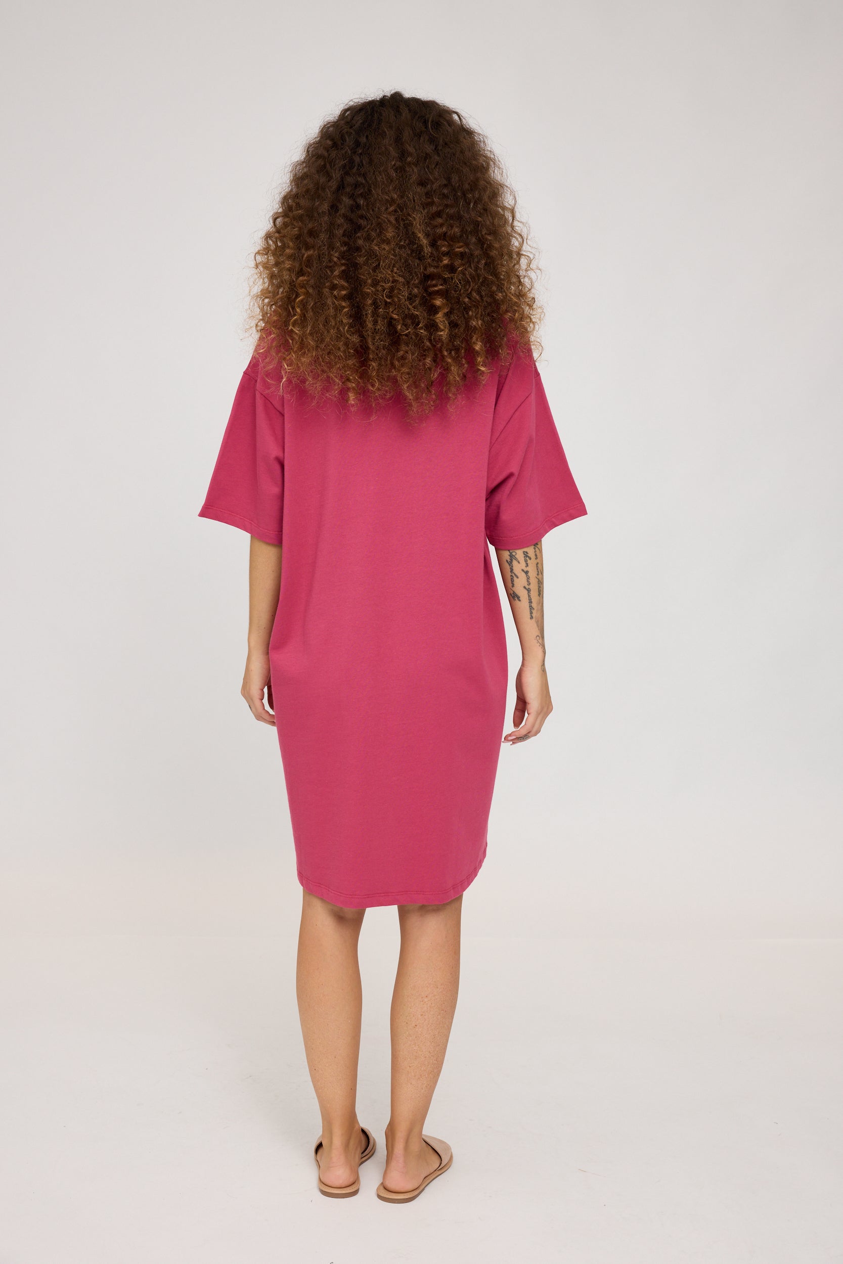Frau in pinkem Kleid von hinten