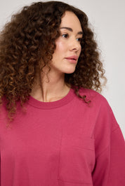Frau in rosa Pullover mit lockigen Haaren