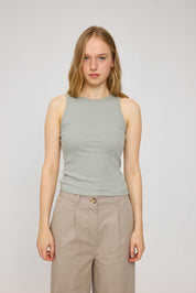 Junge Frau in grauem Top und hellbrauner Hose