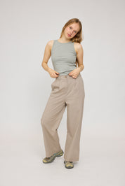 Frau in beiger Hose und grauem Top posiert