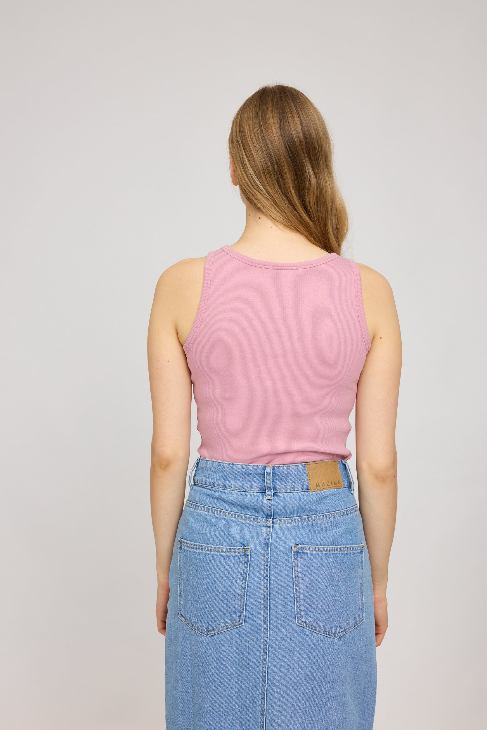 Frau in rosa Top und Jeansrock von hinten