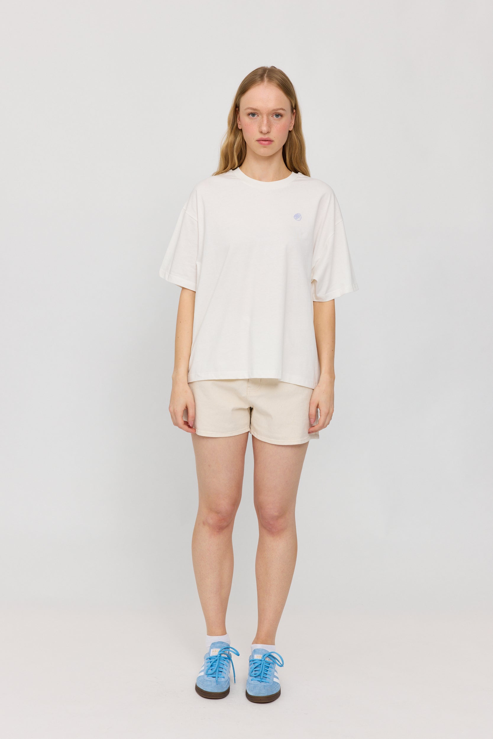 Frau in weißem Shirt und beigen Shorts