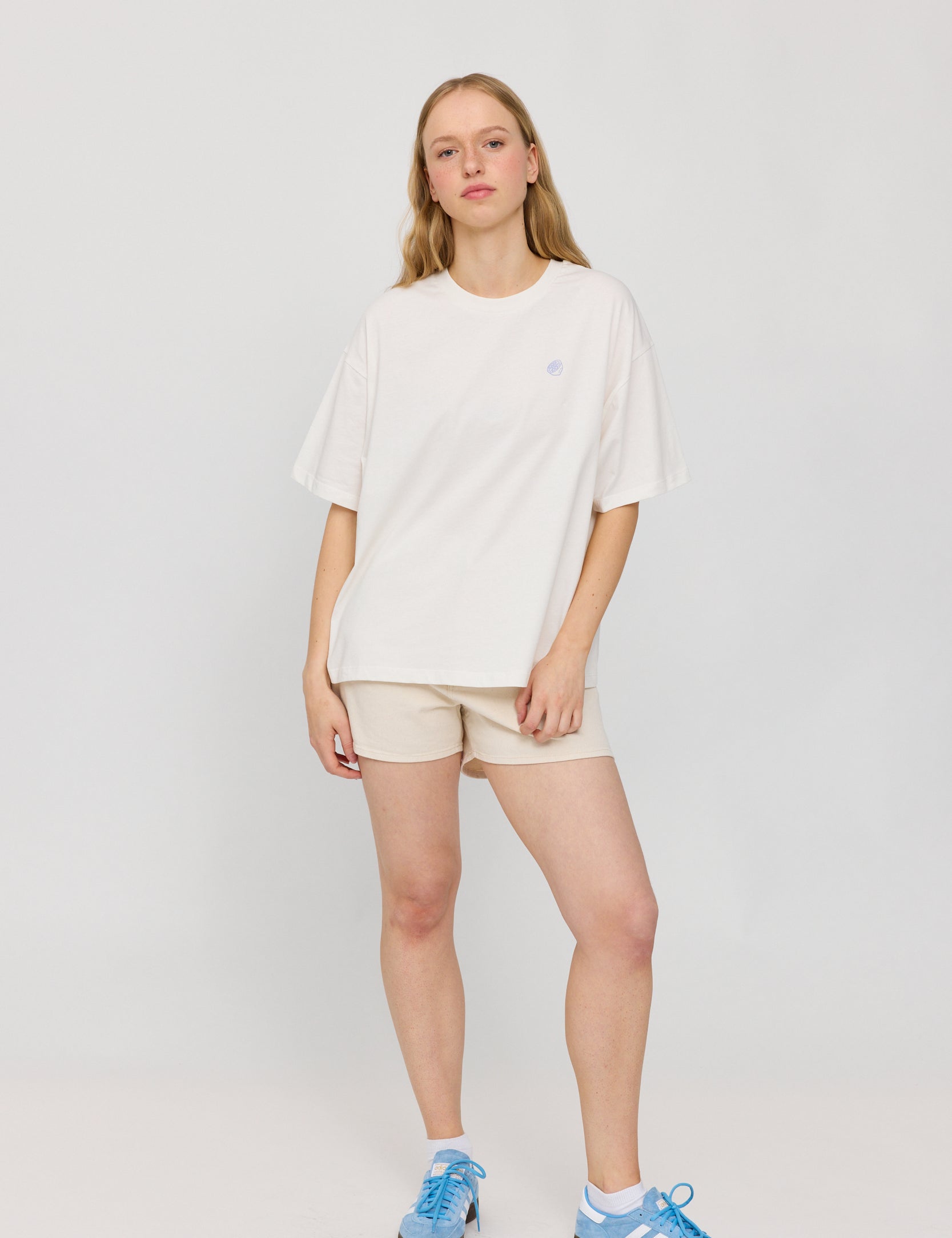 Frau in weißem Shirt und beigen Shorts