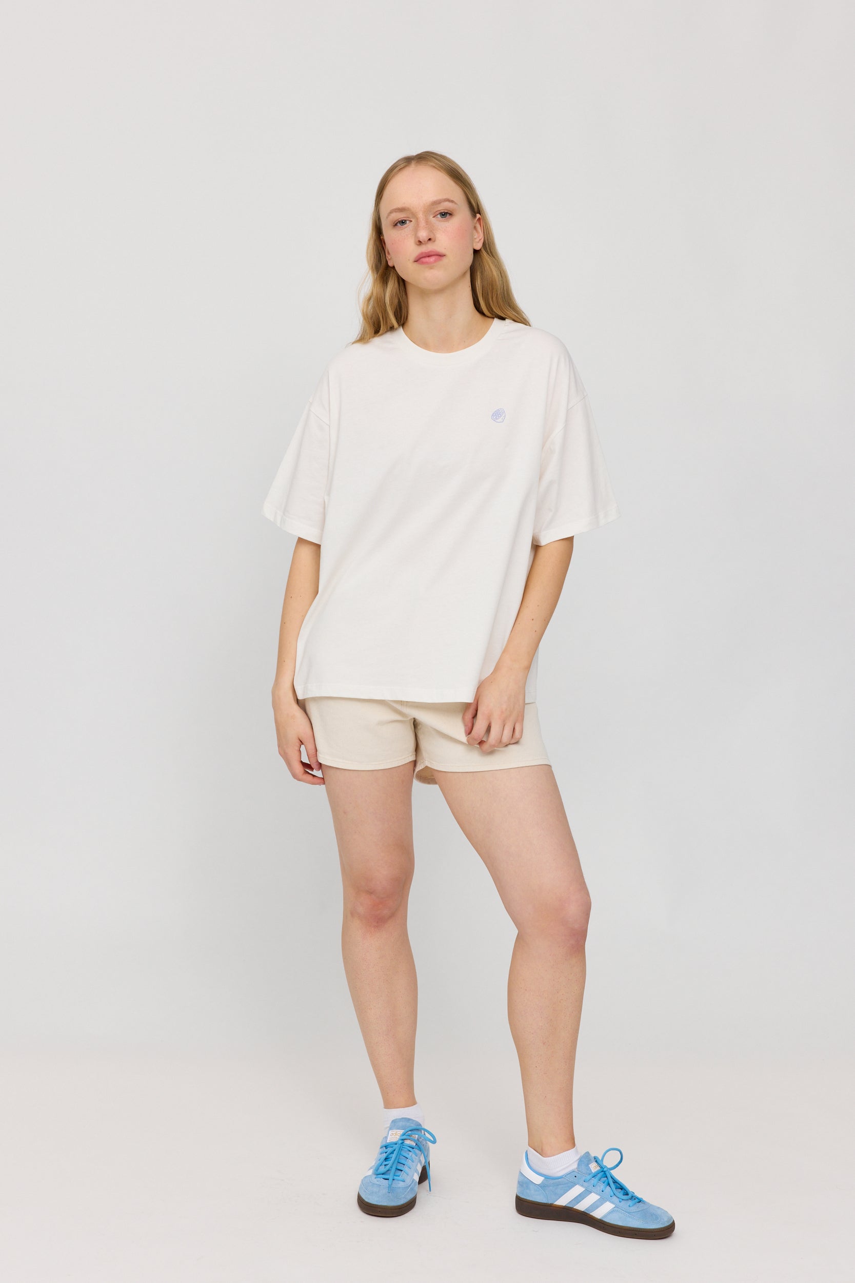 Frau in weißem Shirt und beigen Shorts