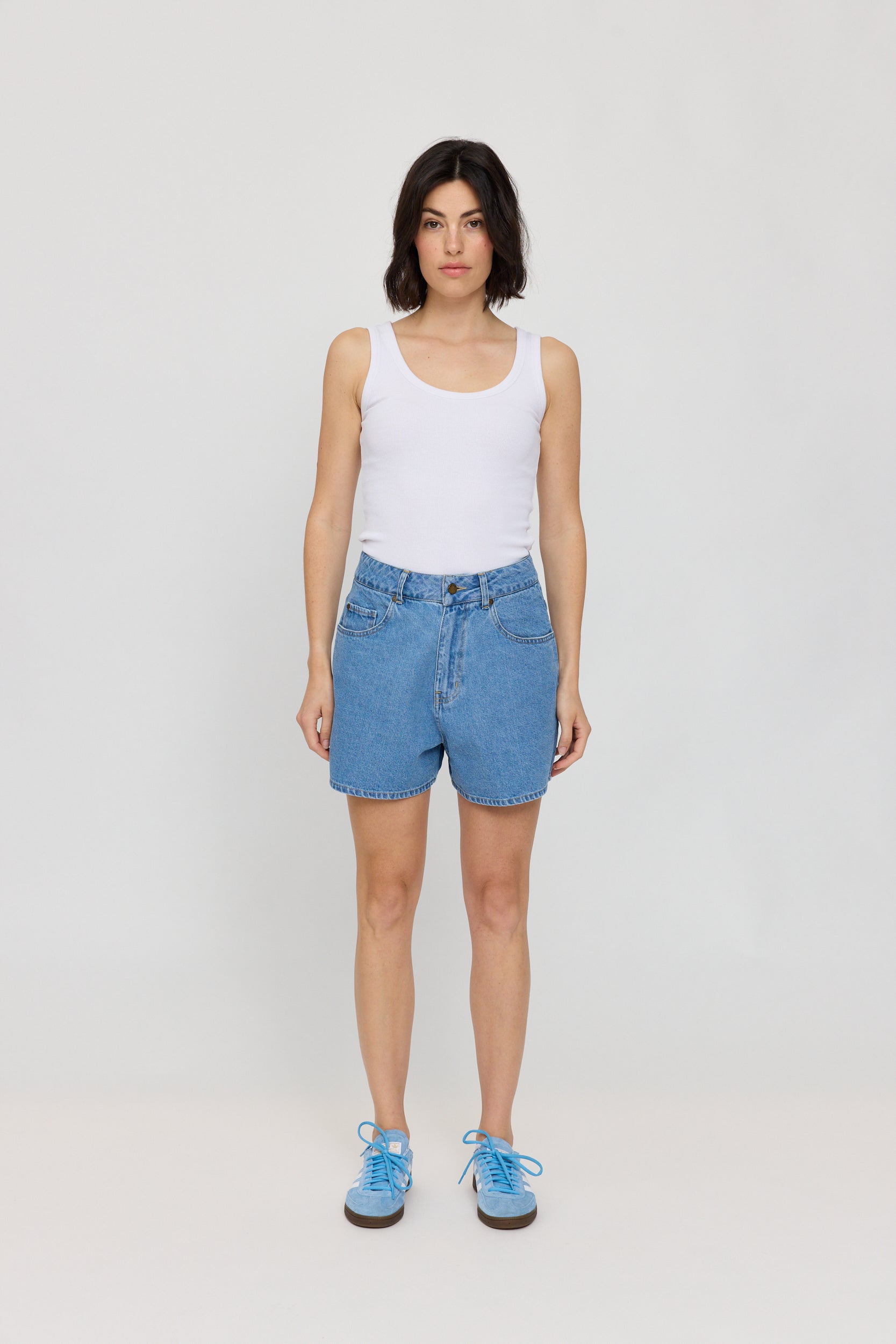Frau in weißen Top und blauen Shorts