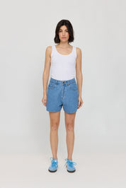 Frau in weißen Top und blauen Shorts