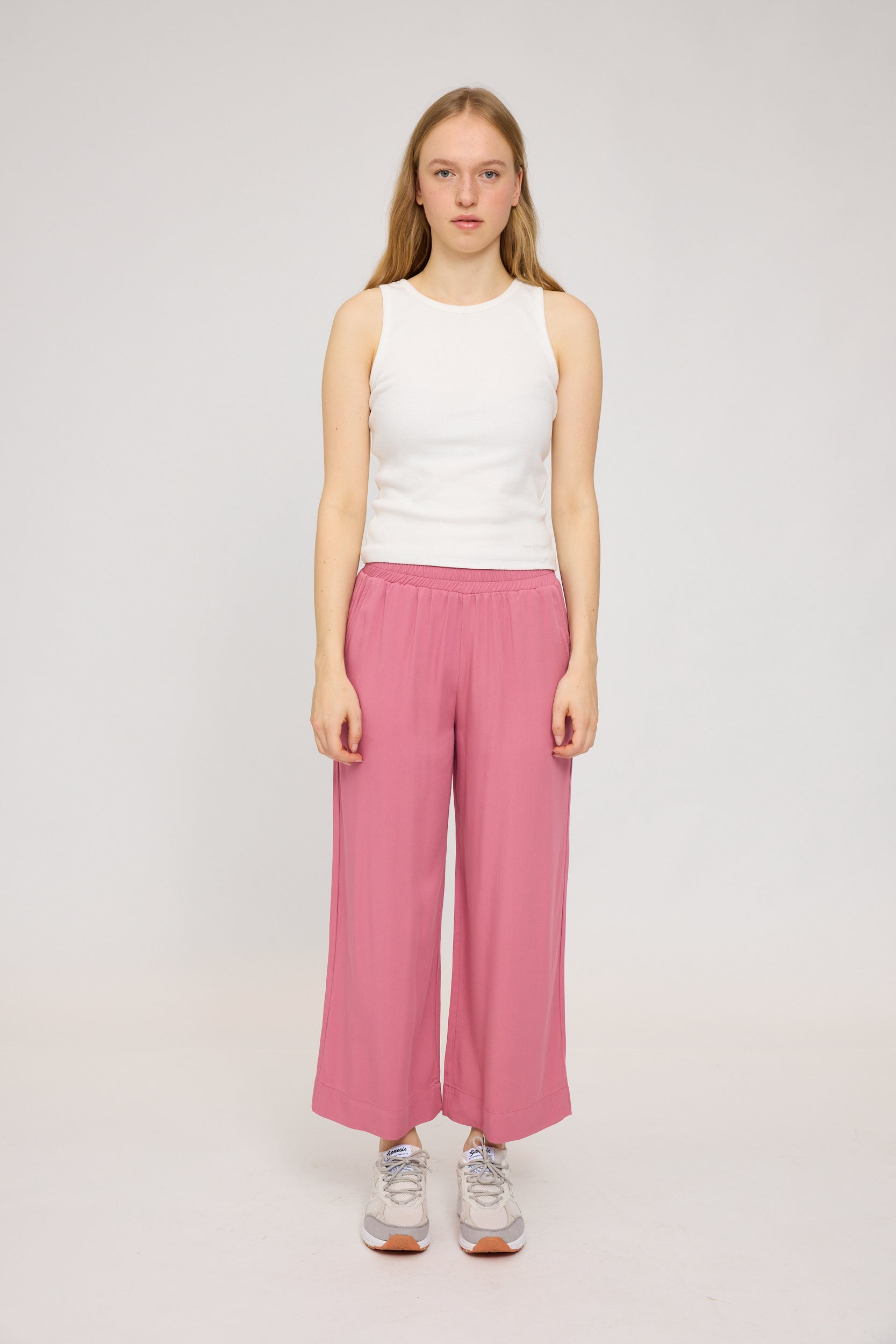 Frau in weißem Top und rosa Hosen