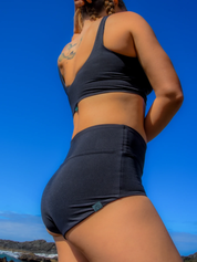 Frau in Sportkleidung am Meer.