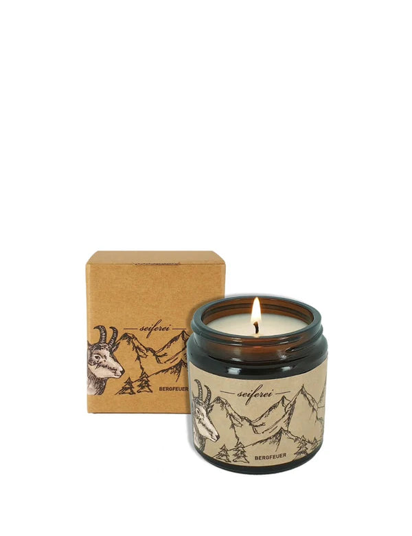 Duftkerze mit Bergmotiv und Verpackung.