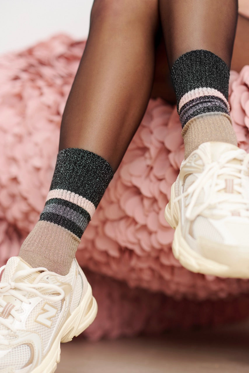 Person trägt modische Socken und helle Sneakers