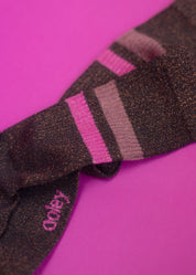 Schwarze glitzernde Fliege auf rosa Hintergrund