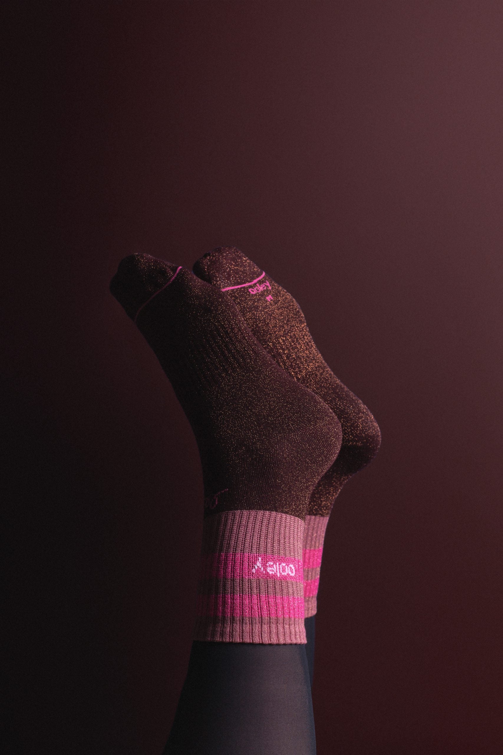 Gekreuzte Füße in rosa-schwarzen Socken