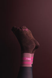 Gekreuzte Füße in rosa-schwarzen Socken
