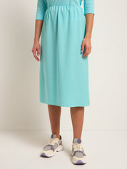 Frau in türkisem Kleid und Turnschuhen.