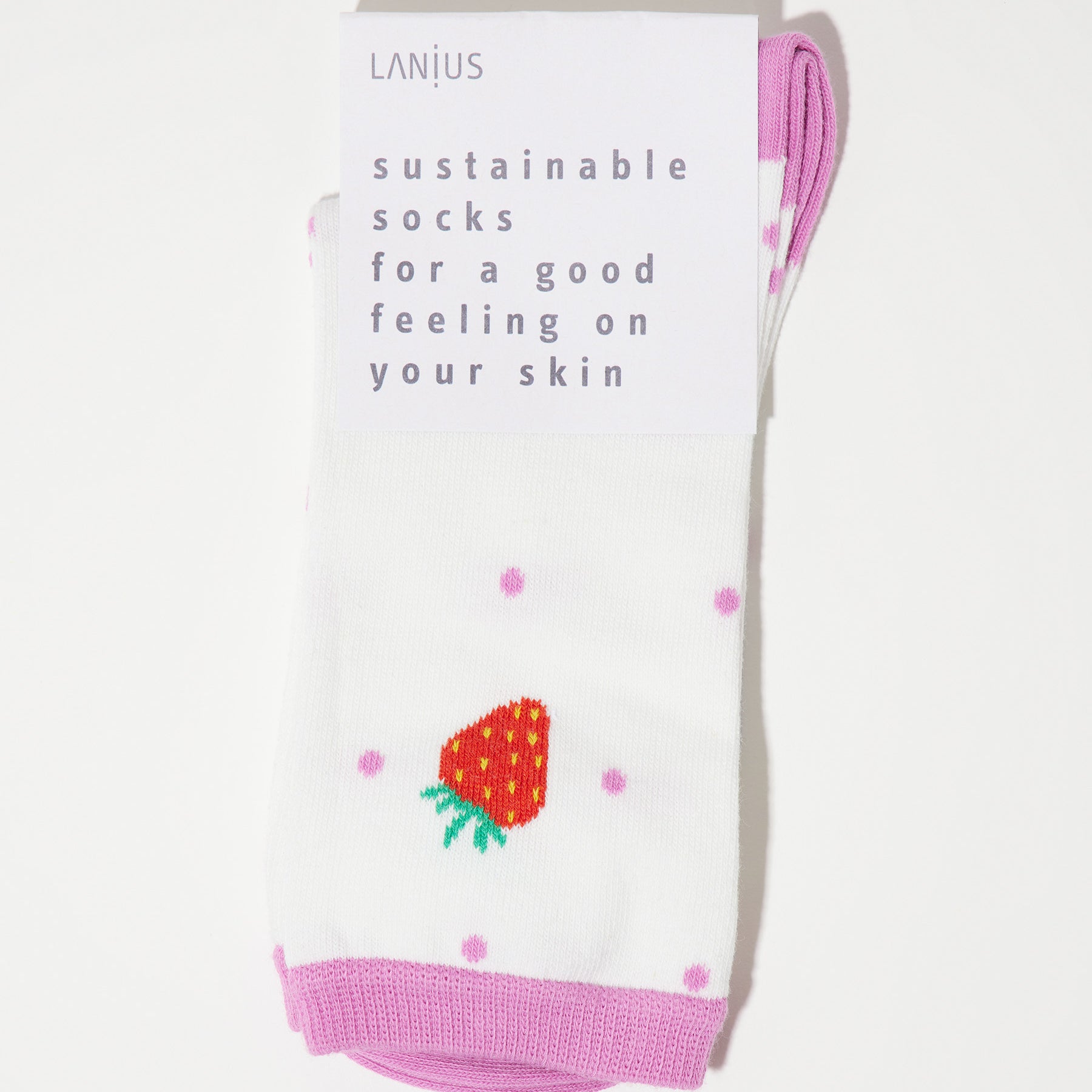 Weiße Socken mit Erdbeermuster und rosa Bündchen.
